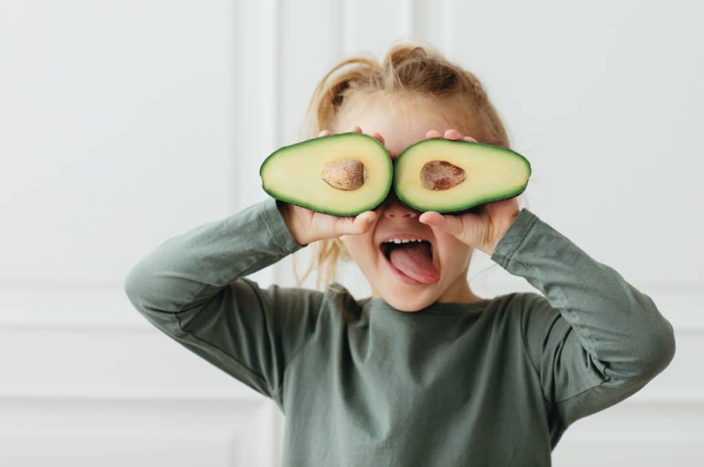 young student with avocados over eyes and tongue out
