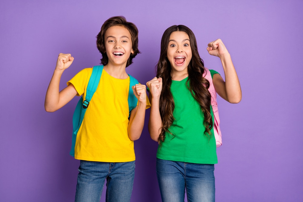 Two teenage students excited about school lunch on purple background