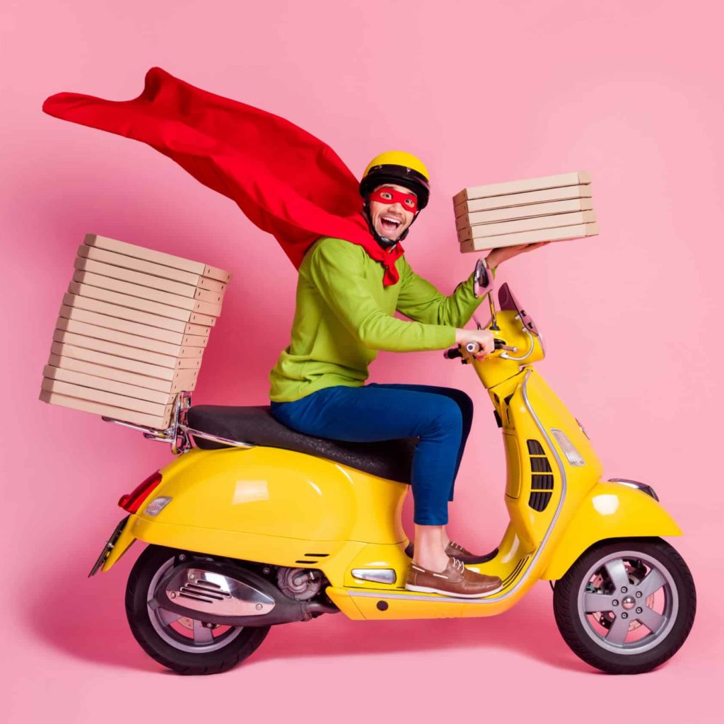 Excited delivery driver with pizzas on pink background